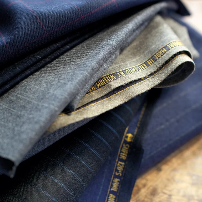 Stack of different fabrics used to make a Tom Fox Bespoke Tailored Suit